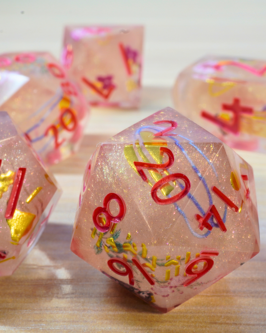Pink polyhedral dice with colorful numbers on a wooden surface